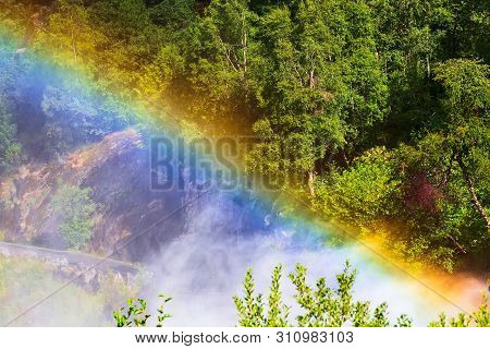 Green Mountain Forest Through Waterfall Rainbow On The Way To Briksdal Or Briksdalsbreen Glacier In 
