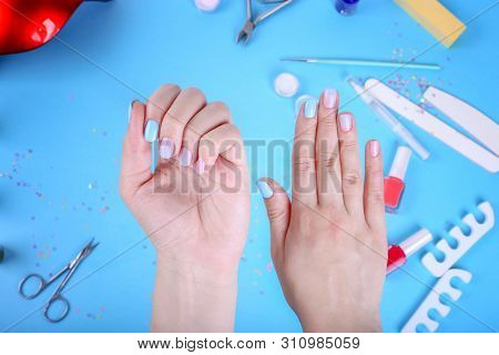 Female Hand With Ombre Manicure On A Blue Background. Blue Manicure With Nail Polish. Top View