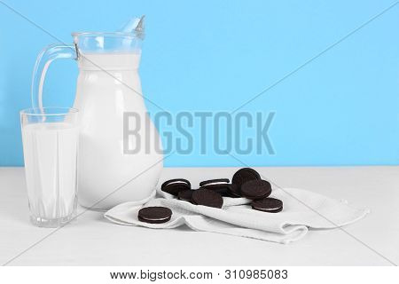 A Pitcher Of Milk And Glass Of Milk With Cookies On A Wooden Table On A Blue Background