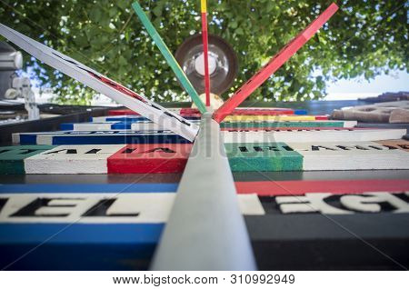 Pole Guidepost With Multiple Destination Countries Of The World On Arrows Sticks In Spanish. Low Ang
