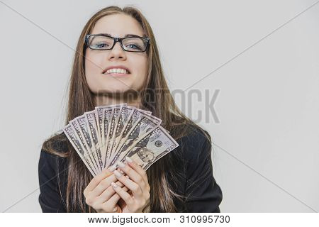 Happy Excited Young Business Woman Is Showing A Pile Of Money, Isolated On White Background. Girl Is