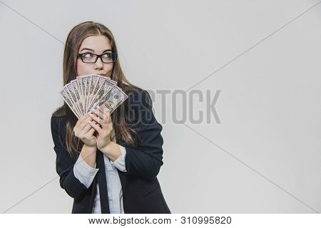 Happy Excited Young Business Woman Is Showing A Pile Of Money, Isolated On White Background. Girl Is