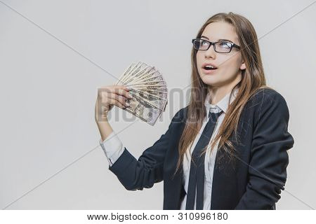 Happy Excited Young Business Woman Is Showing A Pile Of Money, Isolated On White Background. Girl Is