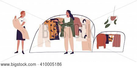 Young Woman Choosing Fashion Apparel With Help Of Shop Assistant In Clothing Store. Seller And Buyer