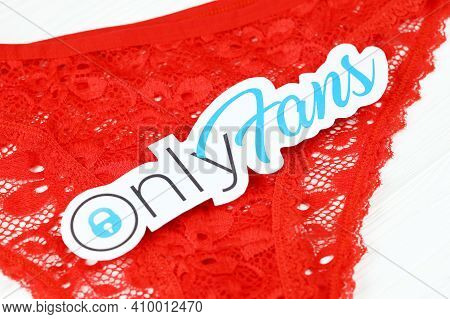 Kharkov, Ukraine - February 14, 2021: Onlyfans Paper Logo And Red Bikini Lingerie On White Table. On