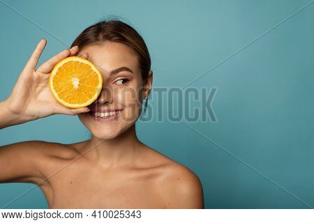 Attractive Caucasian Female With Clean Skin Laughing With Closed Eyes And Showing Half Of Fresh Oran