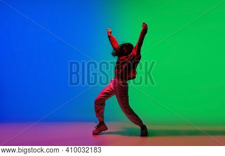 Modern. Stylish Sportive Girl Dancing Hip-hop In Stylish Clothes On Colorful Background At Dance Hal