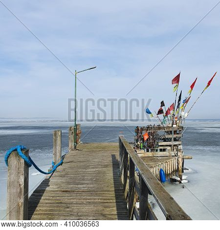 A Short Wooden Pier On The Shore Of The Frozen Sea