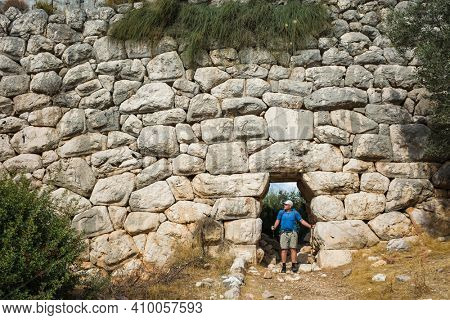 Hiking the Lycian Way. Man is trekking through doorway of Delikkemer Aqueduct, well-preserved polygonal masonry wall, Outdoor activity in Turkey