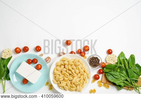 Ingredients For Oven-baked Feta Cheese With Tomatoes And Pasta, Pepper Garlic On A Light Background