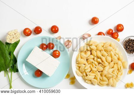 Ingredients For Oven-baked Feta Cheese With Tomatoes And Pasta, Pepper Garlic On A Light Background