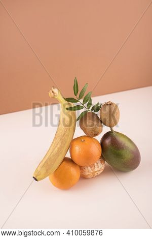 Creative Concept With Flying Fruits. Orange, Two Kiwi, Mango On The Color Background. Levity Fruit F