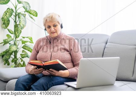Elderly Woman With Bible And Laptop In Front Of Her Connected To Online Church Services Durring The 