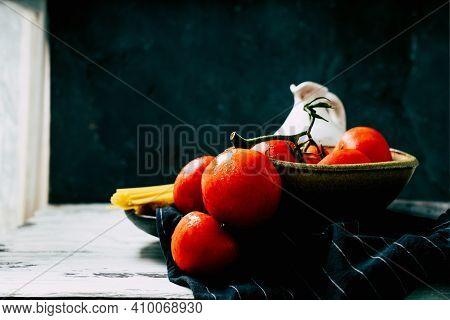 Uncooked Spaghetti,  Organic Tomatoes And Jug Of Olive Oil