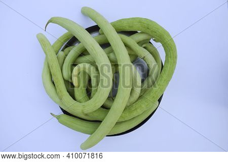 Yard-long Snake Cucumbers Heap, Very Long Thin Curvy Light Green Cucumber Bunch On White Background.