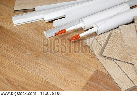 Set Of Items For Pvc Ceiling Indoor Works. Assembly Adhesive Bottles And Pvc Panels With Plastic Cor