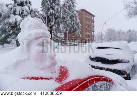 Snowman On Top Of A Snow-covered Car In Madrid's Filomena Storm. Spain