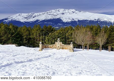 Stone Fountain In The Mountain With Snowy Landscape And Trees Around. Morcuera.