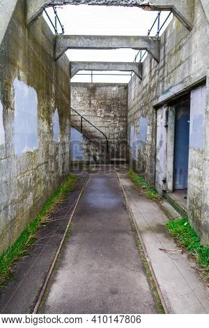 Abandoned Ruins Of An Old Costal Artillery Emplacement With Rail Road Tracks Leading To Viewer Throu