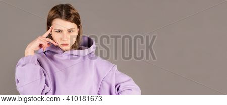 Beautiful Female With Puzzled Expression, Keeps Finger On Head, Looks Aside With Bewilderment, Poses