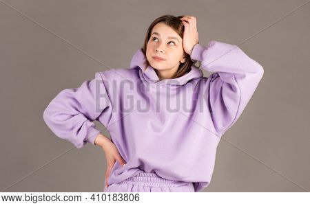 Beautiful Female With Puzzled Expression, Keeps Hand On Head, Looks Aside With Bewilderment, Poses A