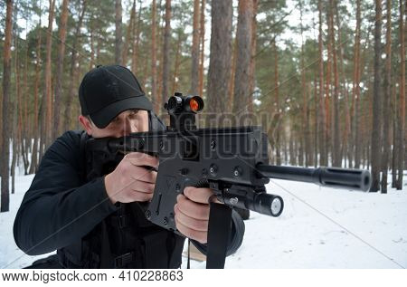 Man with KRISS Vector 9*21 caliber submachine gun in the winter forest. Unformal shooting range near Kiev.February 27, 2021. Kiev Region, Ukraine