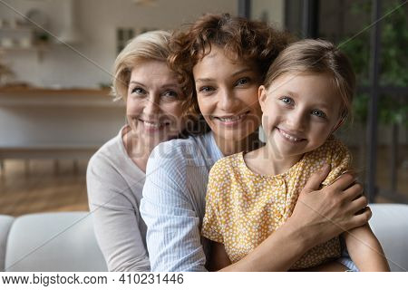 Intergenerational Family Dynasty Of Three Diverse Women Cuddle On Sofa
