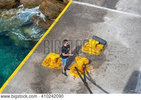 Sikinos, Greece - September 26, 2020: Harbor Worker With Rope In The Alopronia Port Of Sikinos. Cycl