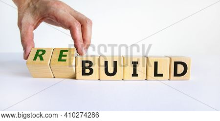 Time To Rebuild Symbol. Businessman Turns Wooden Cubes And Changes The Word 'build' To 'rebuild'. Be