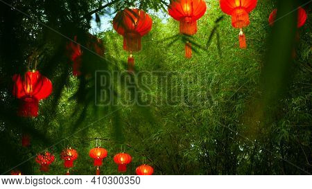 Rows Of Traditional Chinese Style Red Lanterns Hanging On Bamboo Tree Tunnel Arch.