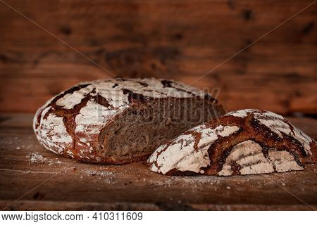 Freshly Cut Crusty Bread On Rustic Wooden Table. Traditional Homemade Bread. Close-up With Short Dep