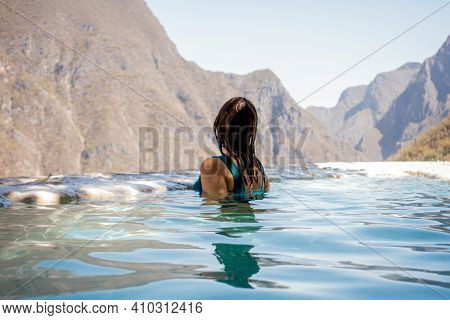 Beautiful Woman In A Blue Swimsuit In The Water In Front Of A Huge Mountains In A Grotto In Tolanton