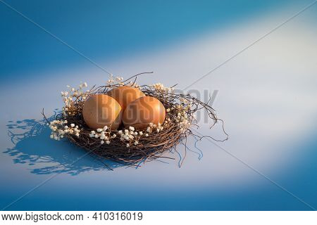 Easter Basket And Spring Flowers With Easter Eggs On Wooden Background With Morning Sunny Window Lig