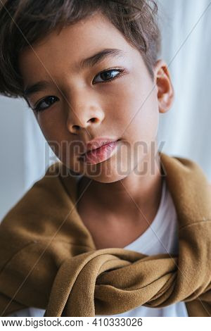 Close Up Portrait Of An Indian Asian Kid. Long Sleeve Tied On His Shoulders.