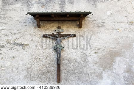 Antique Old Jesus Cross Made Of Wood On A Monastery Wall, Above The Cross Is Mounted A Sign With The