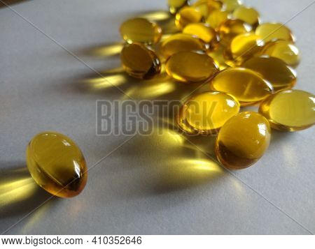 Herbal Oil, Cold Pressed Vitamin Capsule, Body Care Drug. Yellow Shiny Oil Health Supplement