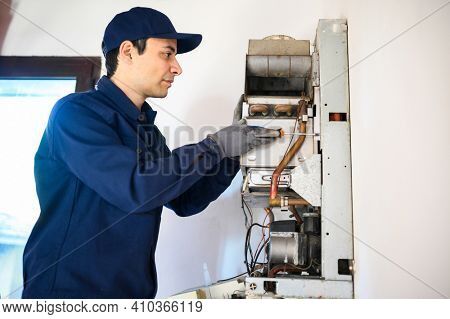 Smiling technician repairing an hot-water heater