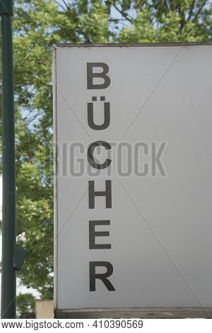 White Library (bücherei) Sign With Black Letters, Tree In Background