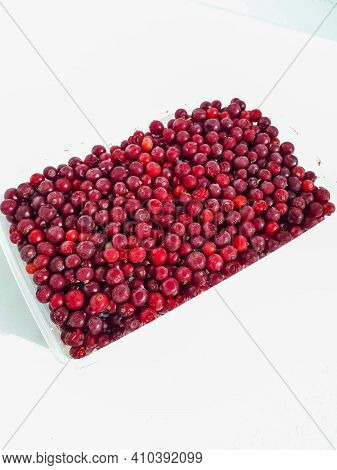 Red Currants In A Plastic Container On White Background