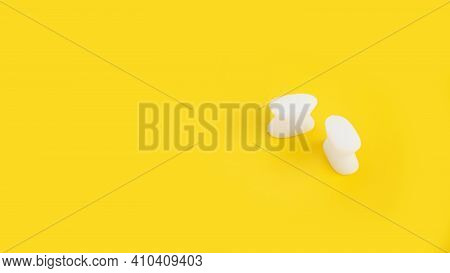 White Silicone Finger Divider On A Yellow Background. Prevention And Treatment Of Hallux Valgus