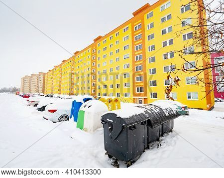 Garbage Cans And Containers For Sorted Waste On The Edge Of The Parking Lot In Front Of Large Prefab