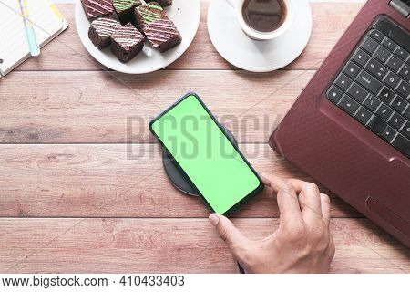Top View Of Man Hand Using Smart Phone On Office Desk