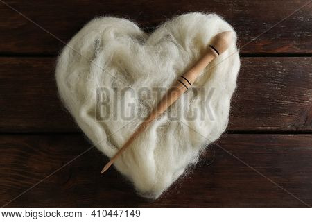 Heart Shaped Pile Of White Wool And Spindle On Wooden Table, Top View