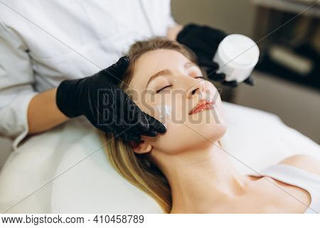 Cosmetologist Applying Cream Essence Essential Vitamins Into Face To Improve Client Skin. Beauty Exp
