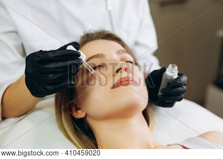 Osmetologist Applying Serum Essence Essential Vitamins Oils Water Into Face To Improve Client Skin. 
