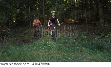 Two Girls On Mtb Bikes. Mother And Daughter Riding On A Forest Trail.