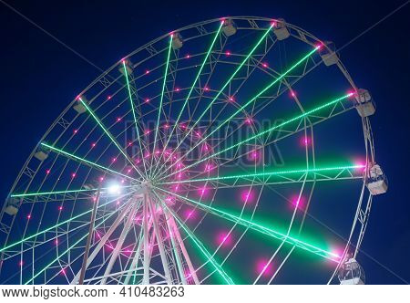 Carnival Ride Showing A Spinning Ferris Wheel In Action- Long Exposure Shot.