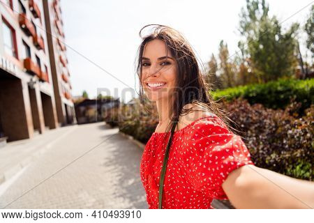 Photo Of Charming Cheerful Young Woman Hold Camera Make Selfie Blogger Outdoors In City Center Outsi