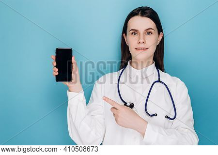 Pozitive Young Female Doctor Pointing Finger At Mobile Screen, Recommend Download Checkup, Consultat