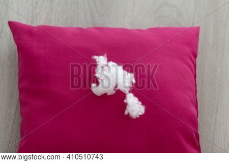 A Lump Of Pillow Filler Lies On A Red Cushion On A Light Wooden Table. Close-up. Selective Focus, Ho